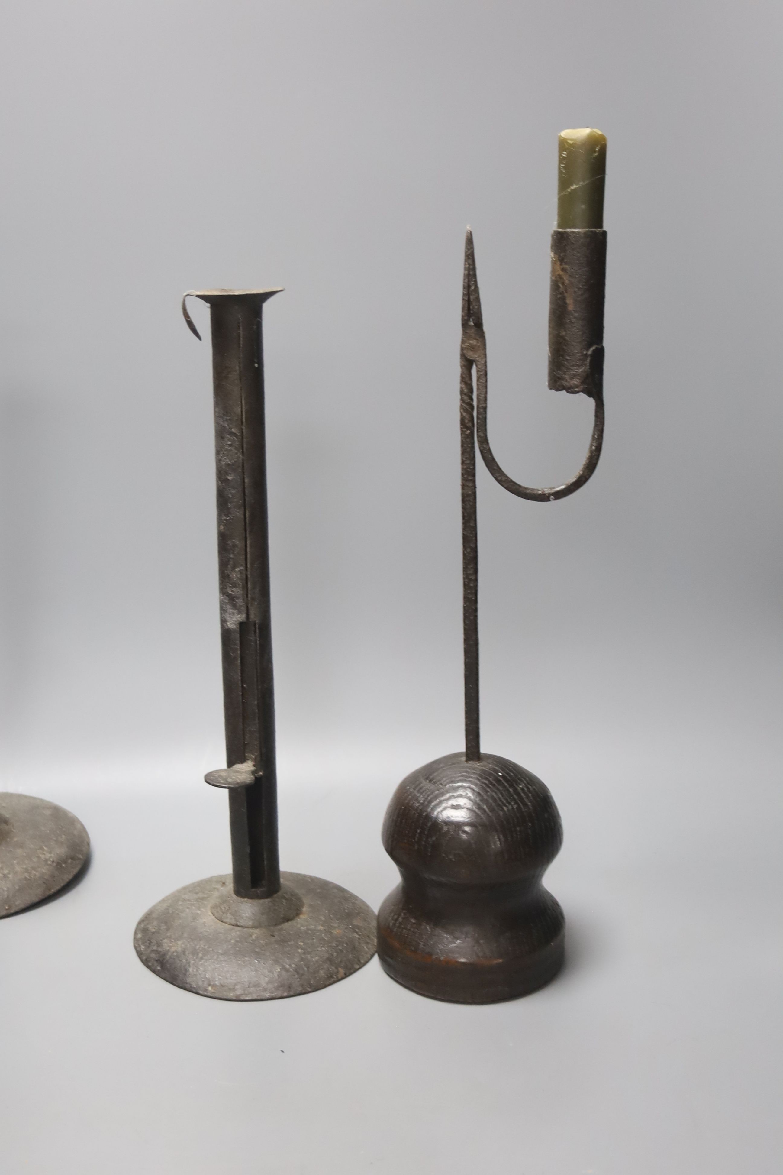 A wrought iron taperstick, a pair of iron telescopic candlesticks, a spiral candlestick, all Georgian and a 17th century style carved wood candlestick (5)